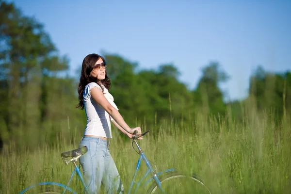 Vrouw met ouderwetse fiets in zomer weide — Stockfoto