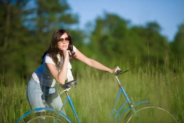 在夏天草地上阳光灿烂的日子的老式自行车的女人 — 图库照片