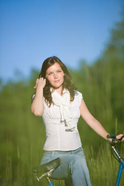 Mulher com bicicleta à moda antiga no prado de verão — Fotografia de Stock