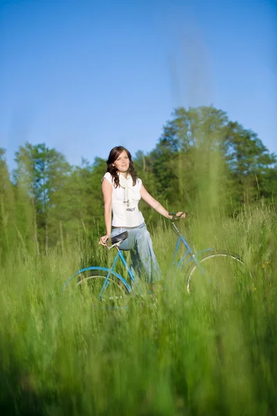 Donna con bici vecchio stile nel prato estivo — Foto Stock