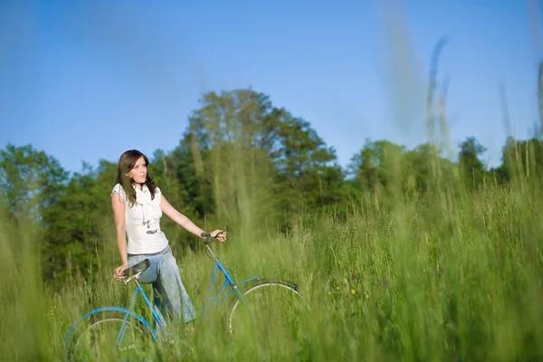 Vrouw met ouderwetse fiets in zomer weide — Stockfoto