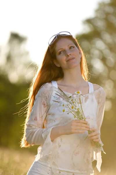 ロマンチックな夕焼けの草原で長い赤髪の女性 — ストック写真
