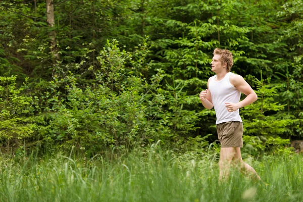 Jeune homme jogging dans la nature — Photo