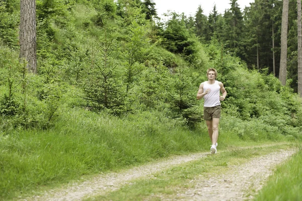 Jonge man joggen in de natuur — Stockfoto