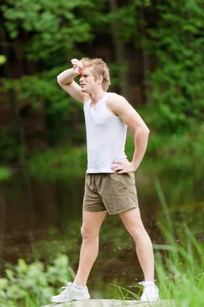 Sportive muž táhnoucí se po tréninku v přírodě — Stock fotografie