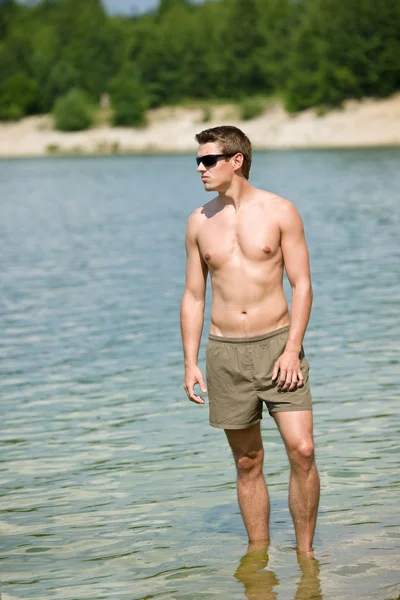 男は水に海岸に立っている太陽を楽しむ — ストック写真