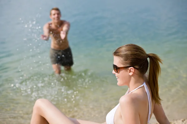 Pareja en la playa - mujer en bikini tomando el sol — Foto de Stock