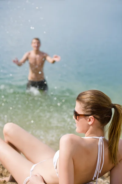 Coppia sulla spiaggia - donna in bikini prendere il sole — Foto Stock
