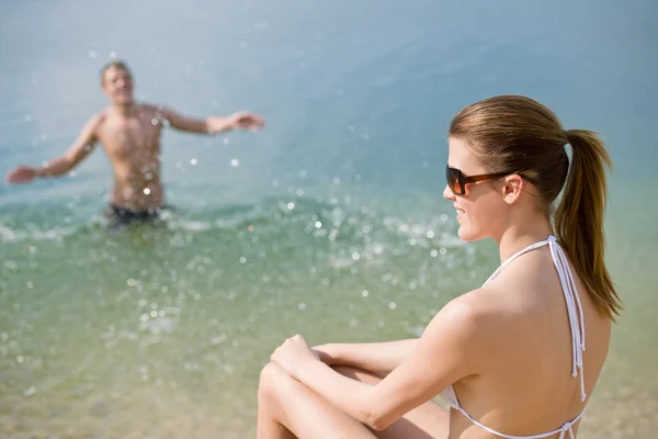 Casal na praia - mulher de biquíni tomando banho de sol — Fotografia de Stock