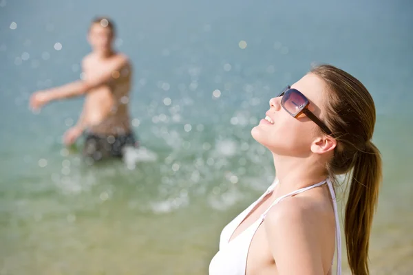Kobieta Bikini Opalanie Nad Morzem Plaży Człowiek Tle Zalewaniem — Zdjęcie stockowe