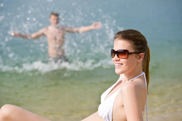 Paar am Strand - Frau im Bikini sonnt sich — Stockfoto