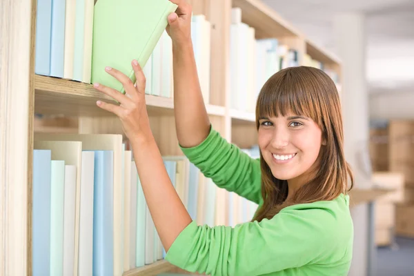 Student in bibliotheek - gelukkig vrouw kiezen boek — Stockfoto
