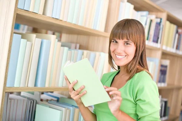 Estudiante en la biblioteca - la mujer alegre escogen el libro —  Fotos de Stock
