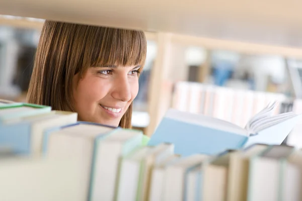 Studente in biblioteca - donna felice studia da libro — Foto Stock