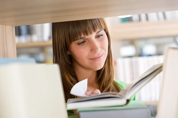 Φοιτητής στη βιβλιοθήκη - ευτυχισμένη γυναίκα διαβάσει βιβλίο — Φωτογραφία Αρχείου