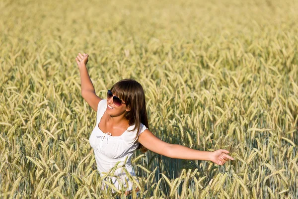 Щаслива молода жінка в кукурудзяному полі насолоджується заходом сонця — стокове фото