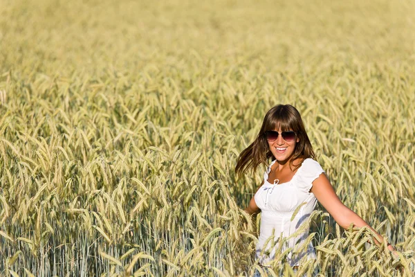 Щаслива жінка в кукурудзяному полі насолоджується заходом сонця — стокове фото