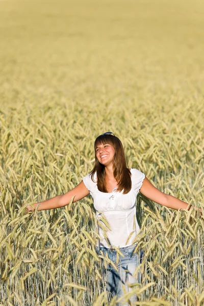 Щаслива молода жінка в кукурудзяному полі насолоджується заходом сонця — стокове фото