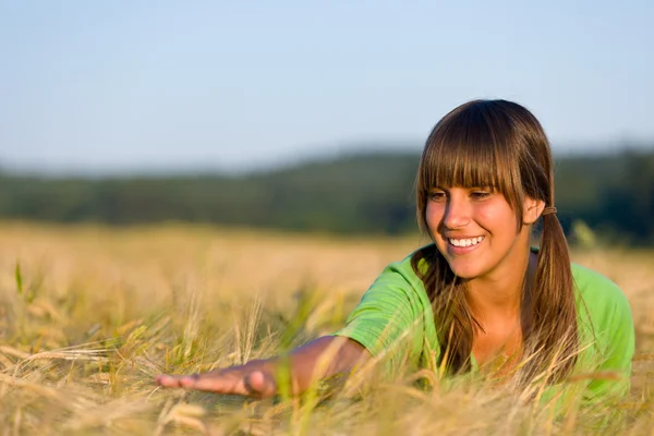 Gelukkige vrouw in zonsondergang maïsveld genieten van zon — Stockfoto