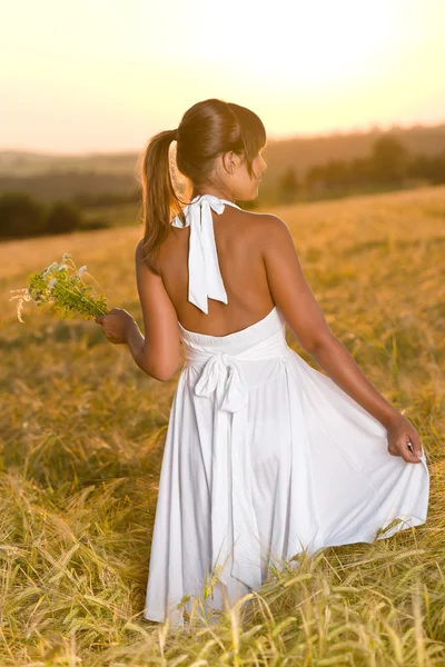 花の花束を持って日没トウモロコシ フィールド摩耗白いドレスでのロマンチックなブルネットの女性 — ストック写真