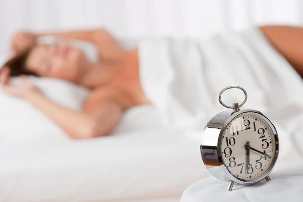 Salón blanco - Reloj despertador de pie sobre cama blanca —  Fotos de Stock