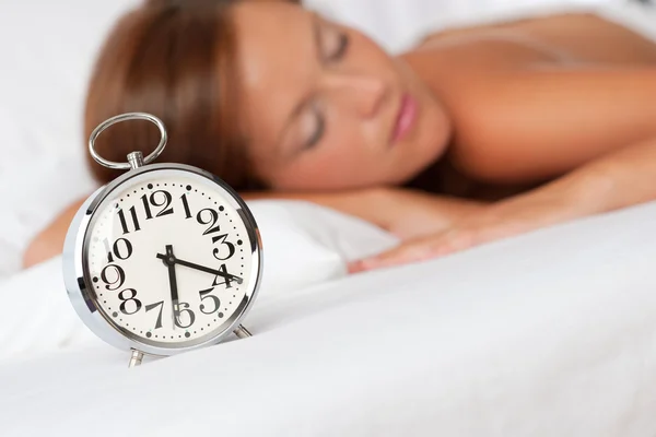 Salón blanco - Reloj despertador de plata en la cama blanca — Foto de Stock