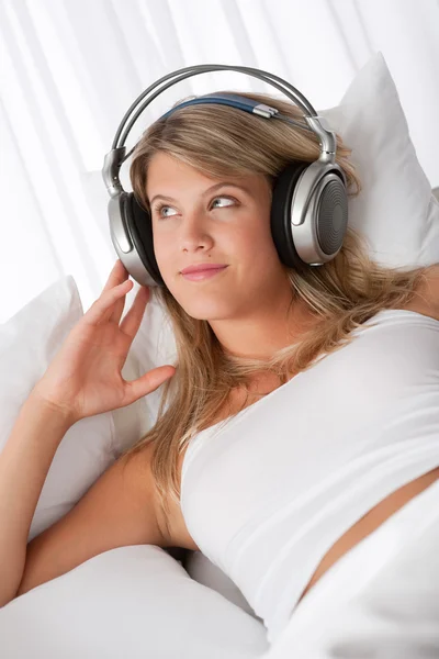 White lounge - Young smiling woman listening to music — Stock Photo, Image