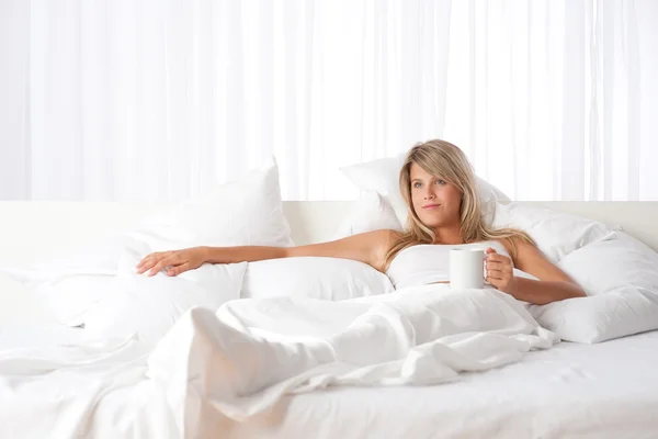 White lounge - Blond woman holding cup of coffee — Stock Photo, Image