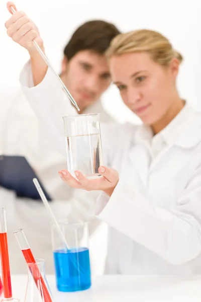 Científicos en laboratorio con productos químicos — Foto de Stock