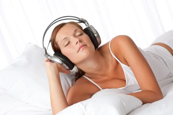 Junge Frau in Weiß mit Kopfhörern — Stockfoto