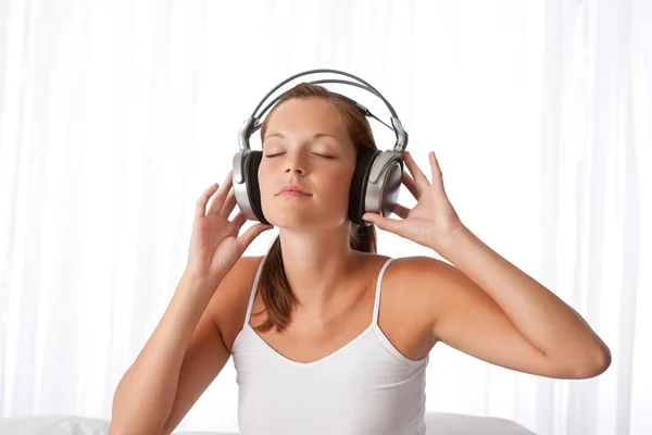 Junge Frau in Weiß mit Kopfhörern — Stockfoto
