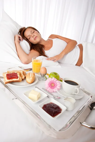 年轻女子在床上吃早餐 — 图库照片