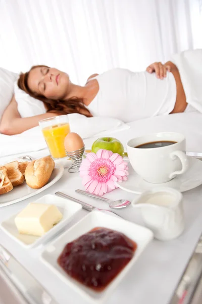 Mladá žena se snídaní v posteli — Stock fotografie