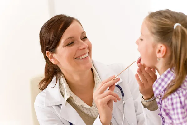 Médico femenino examinando niño con depresor de lengua —  Fotos de Stock