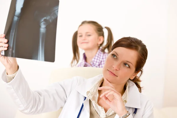 Νεαρή γυναίκα γιατρό δείχνουν ακτινογραφία στο παιδί — Φωτογραφία Αρχείου