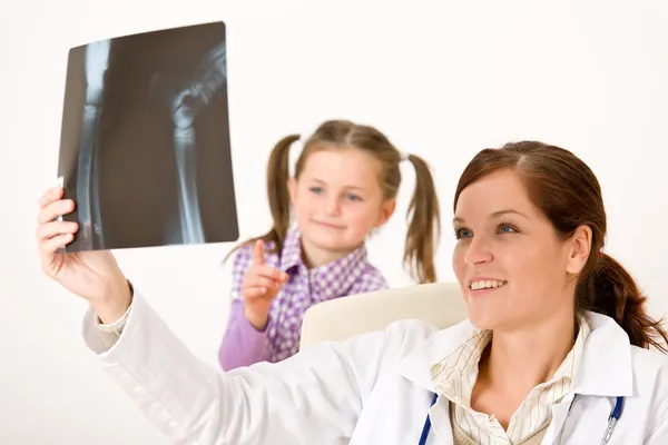 年轻的女医生给儿童看 x 射线 — 图库照片