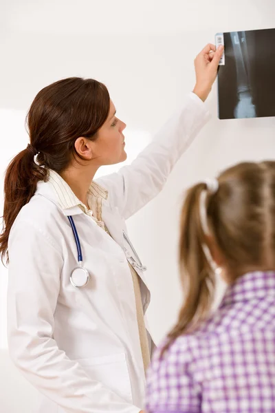 Mladý ženský lékař ukazují x-ray pro dítě — Stock fotografie
