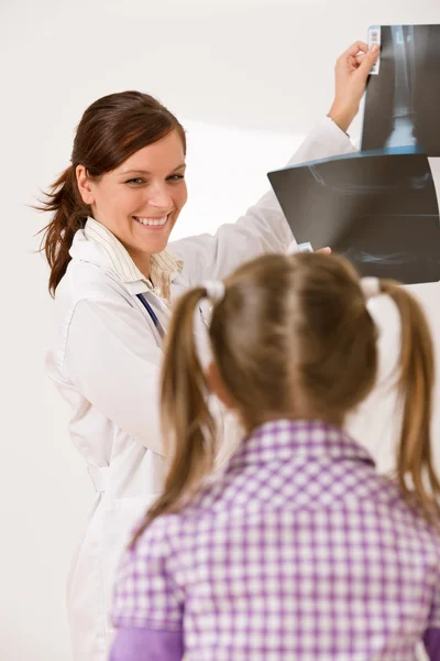 Młoda kobieta lekarz Pokaż x-ray do dziecka — Zdjęcie stockowe