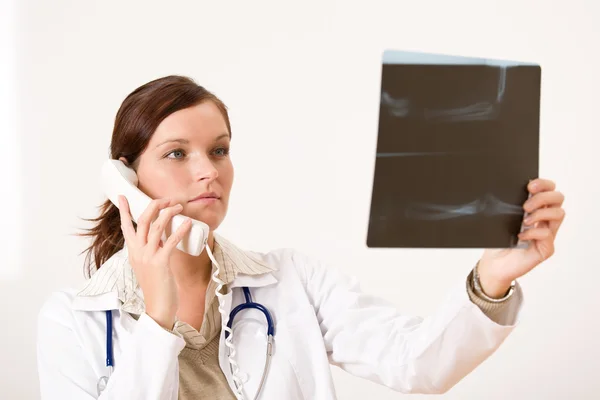 Női orvos, a röntgen és a telefon — Stock Fotó