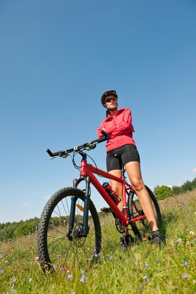 Mladá žena s horské kolo v jarní přírodě — Stock fotografie