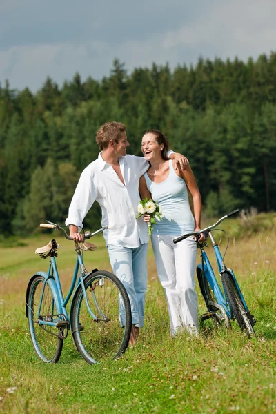 Romantic young couple walking with old bike — Stock Photo, Image