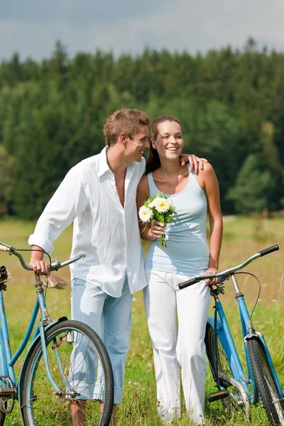 ロマンチックな若いカップルは古い自転車を歩いて — ストック写真
