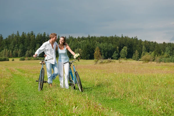 浪漫年轻夫妇与旧自行车弹簧性质上阳光灿烂的日子 — 图库照片