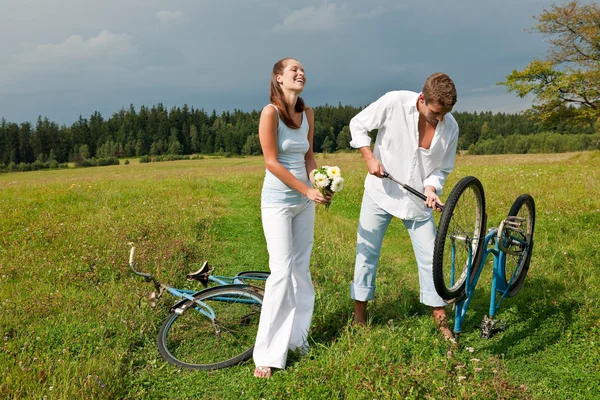 Romantic young couple with old bike in spring nature — Stock Photo, Image