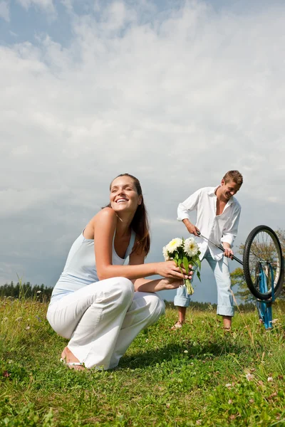 Pareja joven romántica con bicicleta vieja en la naturaleza de primavera — Foto de Stock