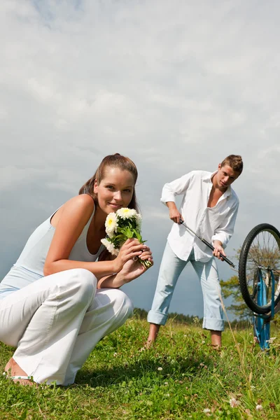 Romantic young couple with old bike in spring nature — Stock Photo, Image