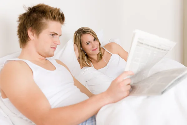年轻的夫妇在床上听听音乐放松 — 图库照片
