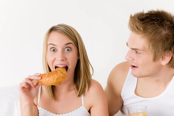 Breakfast - happy young couple eating croissant — Stock Photo, Image