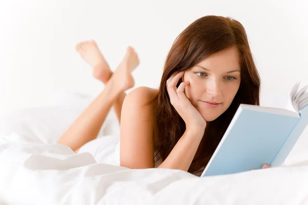 ベッドルーム 若い女性は白いベッドで本を読む — ストック写真