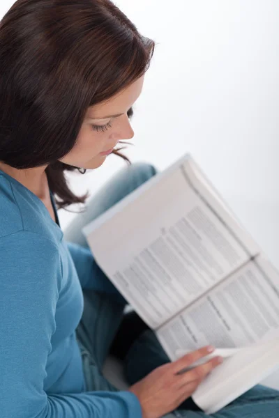 白い背景の上の本を読んで若い茶色の髪の女性 — ストック写真